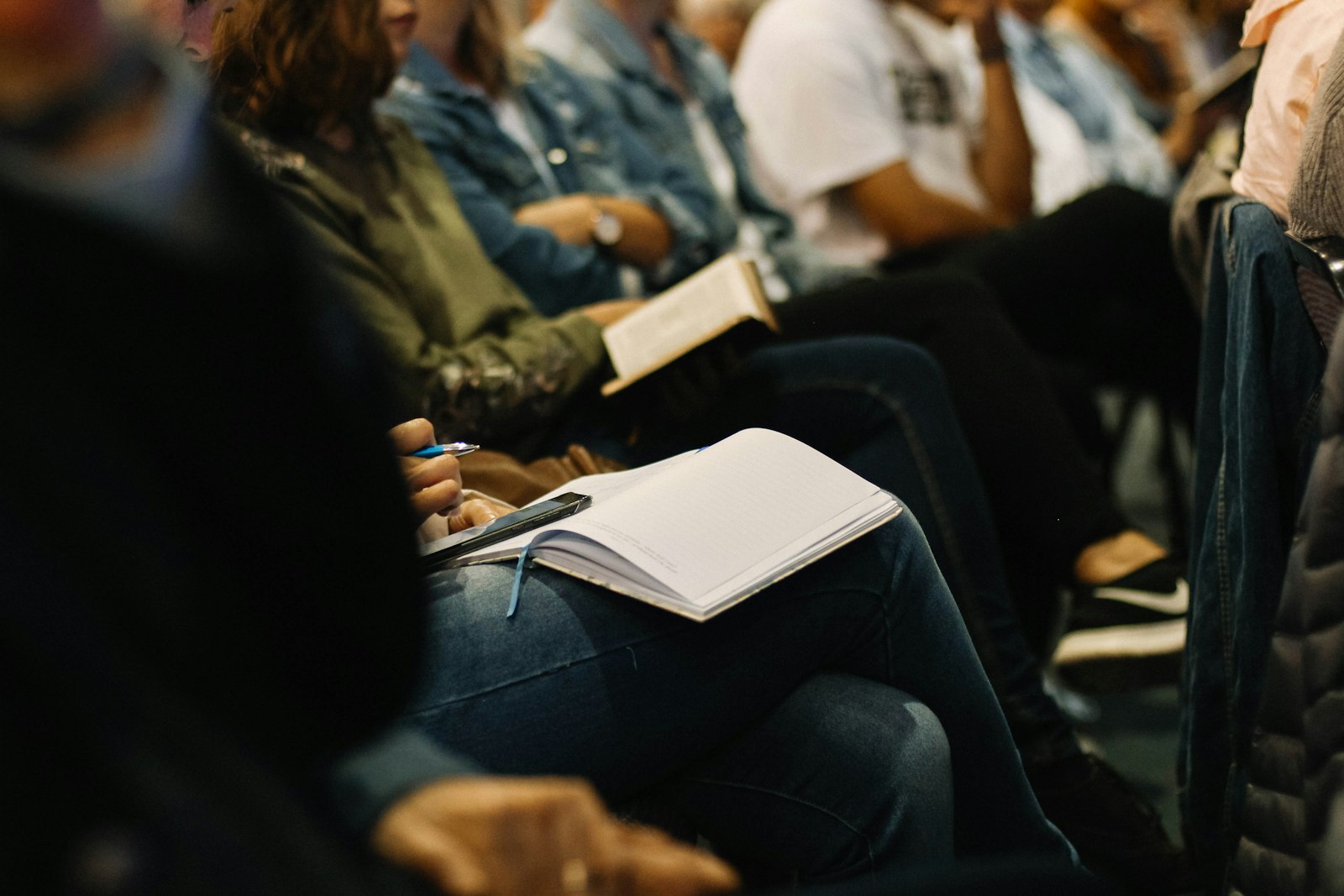 Church attendees taking notes and reading during a gathering