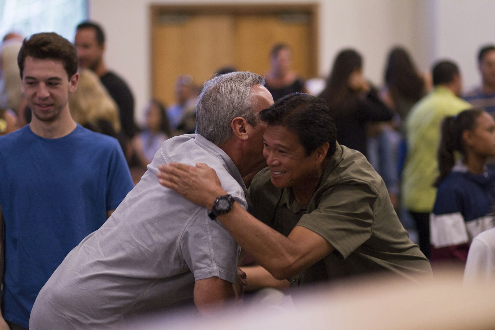 People greeting one another warmly inside a church gathering